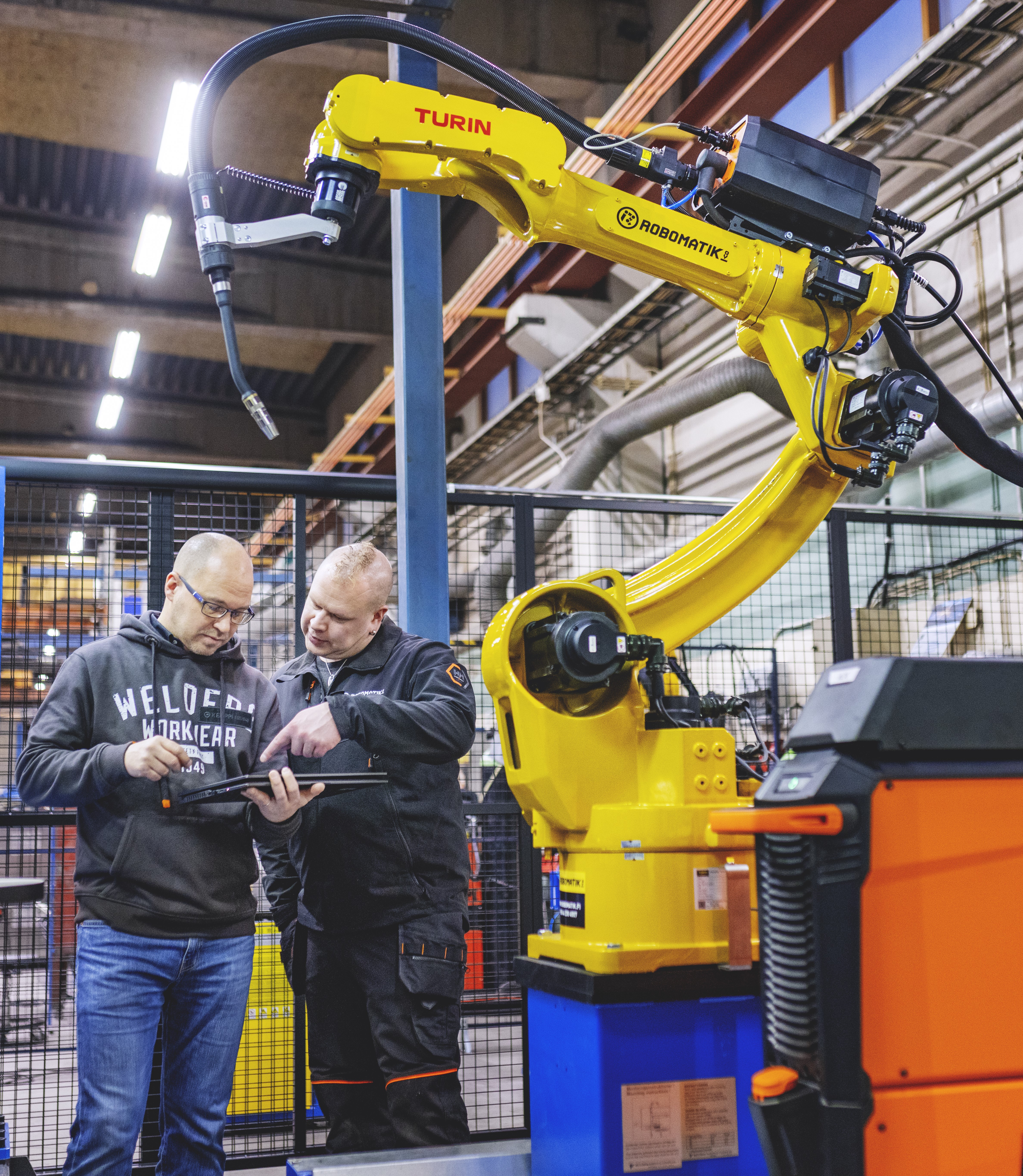In questa foto si vede l'integratore insieme a uno specialista di automazione Kemppi che lavora con un sistema robotico di saldatura